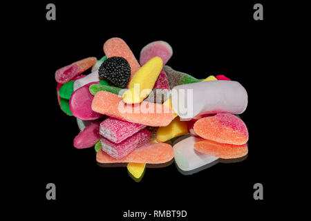 Süßigkeiten und Bunte Jelly Bonbons auf einem schwarzen Hintergrund mit Spiegel isoliert Stockfoto