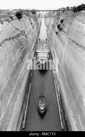 Der Kanal von Korinth mit einer Eisenbahnbrücke. Es ist 6,5 km lang und es wurde 1893 eröffnet. Es verbindet die Halbinsel Peloponnes mit dem Festland. Hier ein Passagierschiff ist von einem Piloten durch den Kanal im Jahr 1984 gezogen. Stockfoto