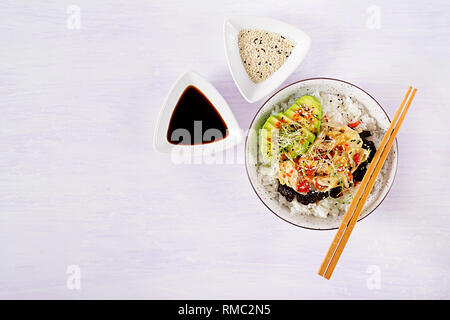 Vegan Salat mit Reis, eingelegte Kimchi Kohl, Avocado, Nori und Sesam auf die Schüssel. Sushi-food-Hybriden Trend. Overhead, Ansicht von oben, flach. Stockfoto