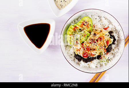 Vegan Salat mit Reis, eingelegte Kimchi Kohl, Avocado, Nori und Sesam auf die Schüssel. Sushi-food-Hybriden Trend. Overhead, Ansicht von oben, flach. Stockfoto