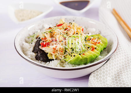 Vegan Salat mit Reis, eingelegte Kimchi Kohl, Avocado, Nori und Sesam auf die Schüssel. Sushi-food-Hybriden Trend. Gemeinkosten Stockfoto