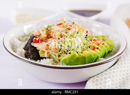 Vegan Salat mit Reis, eingelegte Kimchi Kohl, Avocado, Nori und Sesam auf die Schüssel. Sushi-food-Hybriden Trend. Gemeinkosten Stockfoto