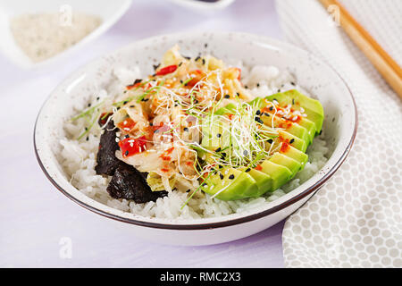 Vegan Salat mit Reis, eingelegte Kimchi Kohl, Avocado, Nori und Sesam auf die Schüssel. Sushi-food-Hybriden Trend. Gemeinkosten Stockfoto