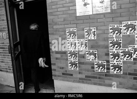 Deutschland, Berlin, 17. März 1990: Der Mann mit Bananen. Poster: 'Der Bär bleibt rot" ("Der Bär rot bleibt"), Straßenszene in Memhardstrasse. Stockfoto