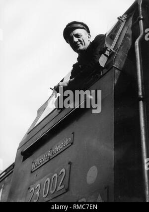 Ein Lokführer schaut aus der Kabine einer Lokomotive. Stockfoto