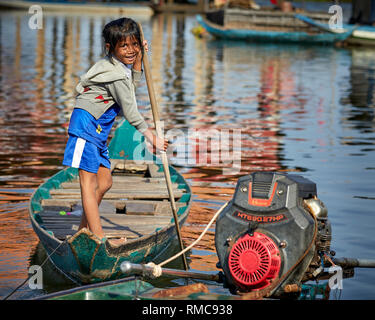 Tonlé Sap See, Kambodscha. 19. Dezember, 2017. Der junge Fischer Tochter auf Tonlé Sap Sees steht und Zeilen ihr Holzboot. Stockfoto