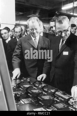 Bundeskanzler Willy Brandt (2. von rechts) neben dem Kopf des Rotary Abteilung Erwin Hottelet, der in Bewegung setzt einen neuen Rotationspresse in der Zeitung drucken funktioniert. Brandt wurde in München anlässlich der 50-Jahr-Feier der Sueddeutschen Zeitung. Stockfoto