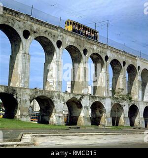 Die 'Aqueduto da Carioca", auch "Arcos da Lapa", wurde 1750 bis 1896 gebaut, brachte frische Wasser aus der Carioca Fluss, der heute leider in eine Kloake degenerierte. Seit 1896 ist eine Straßenbahn hat auf dem Viadukt betrieben und verbindet den Stadtteil Santa Teresa mit dem Zentrum. Stockfoto