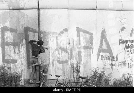 Die Berliner sind auf der Suche in den östlichen Teil der Stadt. Die Berliner Mauer am Potsdamer Platz. Stockfoto