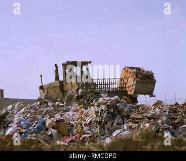 Eine Planierraupe, wenn Abfälle in einer Deponie, im Hintergrund ein Müllauto ist entladen. Stockfoto