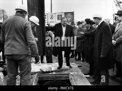 Der bayerische Ministerpräsident Alfons Goppel (Mitte) beim start der Bau der Münchner U-Bahn. Der erste Stahlträger ist Goppel in Position gebracht. Der Münchner Oberbürgermeister Hans-Jochen Vogel (3. von rechts) ist auch vorhanden. Stockfoto