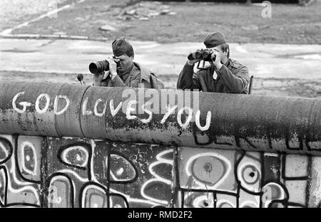 Mitglieder der DDR-Grenztruppen beobachten ein Gas Nutzung durch die West-berliner Polizei gegen die Insassen des sogenannten Lenne Dreieck am Potsdamer Platz. Ende Mai 1988, mehrere hundert Personen besetzt ein Standort in unmittelbarer Nähe der Mauer gegen den Bau einer Autobahn zu protestieren. Als Ergebnis gibt es immer wieder Konflikte mit der Polizei. Stockfoto