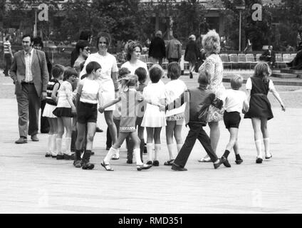 Kindergarten Gruppe am Neptunbrunnen hinter der Fernsehturm am Alexanderplatz in Ost-Berlin. Stockfoto