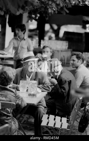 Ansicht von mehreren Herren Bier trinken im Biergarten auf dem Münchner Viktualienmarkt. Stockfoto