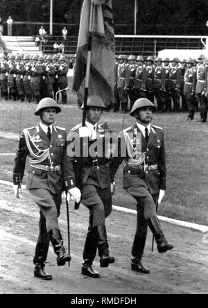 Militärische Zeremonie anlässlich der Vereidigung von Absolventen der offiziershochschule "Ernst Thälmann" der Landstreitkräfte der Nationalen Volksarmee (NVA) der DDR in Löbau, Parade mit Truppe Flagge der OHS. Stockfoto