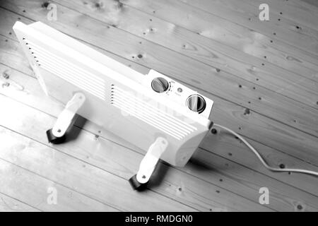 Arbeiten weiß elektrischer Konvektor Heizung mit Bedienfeld oben auf Holzboden in einem Haus Zimmer top View closeup Schwarz und Weiß Foto Stockfoto