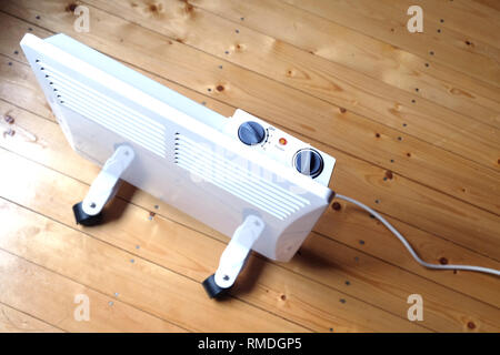 Arbeiten weiß elektrischer Konvektor Heizung mit Bedienfeld oben auf Holzboden in einem Haus Zimmer top View closeup Stockfoto