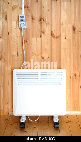 Arbeiten weiß elektrischer Konvektor Heizung angeschlossen, um timer Energie intelligenten Steckdose im Smart house System gegen hölzerne Wand im Zimmer vertikale fr betrieben Stockfoto
