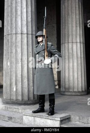 Schutz der Nationalen Volksarmee (NVA) der DDR mit Gewehr vor der Neuen Wache auf dem Boulevard Unter den Linden in Ost-Berlin. Stockfoto