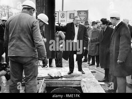 Zu Beginn der Bau der Münchner U-Bahn: Ministerpräsident Alfons Goppel (Mitte) mit dem ersten Stahlträger. 2. von rechts Oberbürgermeister Hans-Jochen Vogel und Bürgermeister Georg Brauchle (hinter dem Vogel) auf die Schenkendorfstraße, der heutigen Nordfriedhof stoppen. Stockfoto