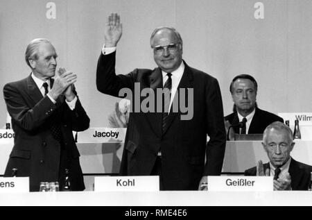 Bundeskanzler Helmut Kohl nimmt seine Wiederwahl als Bundesvorsitzende der CDU auf dem Bundesparteitag der CDU in Bremen. Links von ihm Karl Carstens, der ehemalige Bundespräsident. Rechts von ihm, Generalsekretär Heiner Geißler. Stockfoto