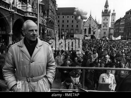 Grüne Politiker und ehemalige Major General Gert Bastian an der Ostermaersche auf dem Münchner Marienplatz. Eine Demonstrantin hält ein Banner mit der Aufschrift "ucceed anstelle von Nachrüstung". Im Hintergrund, das alte Rathaus. Stockfoto