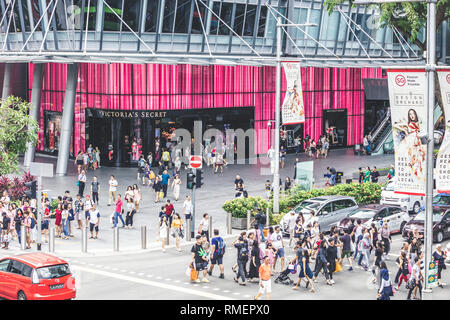 Singapur/Singapur - 10. Februar 2019: Fußgänger jagt Kreuzung an der Orchard Road Somerset Kreuzung mit Victoria Secret Store Stockfoto