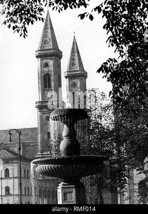 Brunnen vor der Ludwig-Maximilians-Universität und der Kirche St. Louis in München. Stockfoto