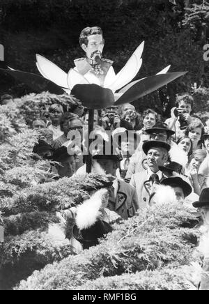 Dieses Foto zeigt ein Ereignis der Koenig-Ludwig-Treuen am 90. Jahrestag des Todes des Königs. Sie tragen einen Mitarbeiter mit dem Porträt von König Ludwig II. in eine Blüte durch die Straße. Stockfoto