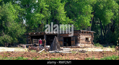 Zwei reenactors stand neben einem Wagen vor einer Hütte am El Rancho De Las Golandrinas außerhalb von Santa Fe, New Mexico. Stockfoto