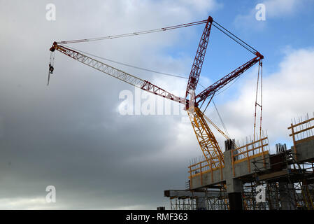 Ein großer Kran überschattet eine Stadt Baustelle Stockfoto