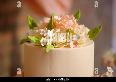 Elegante formale tiered Kuchen mit oben wunderschön dekoriert mit Puderzucker Blumen und in samtig Royal icing vorbereitet für eine Hochzeit abgedeckt Stockfoto