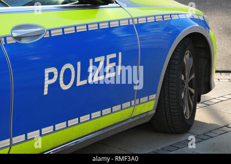 Seitenansicht der deutschen Polizei Auto mit blauen und gelben Lackierung auf Gehweg in einer Stadt Stockfoto