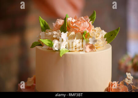 Elegante formale tiered Kuchen mit oben wunderschön dekoriert mit Puderzucker Blumen und in samtig Royal icing vorbereitet für eine Hochzeit abgedeckt Stockfoto