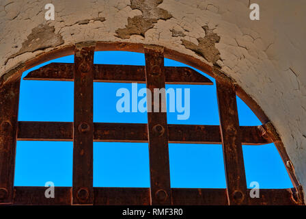 Closeup Abschnitt der verrostete Bars über eine Öffnung in einer alten Zelle mit blauen Himmel im Hintergrund Stockfoto