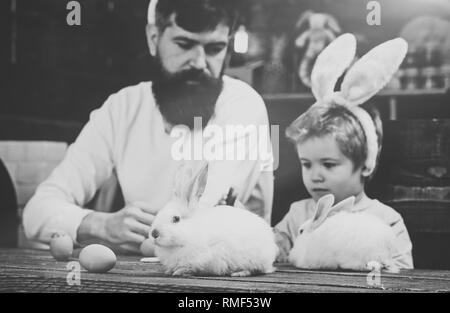 Kind und Vater holding Korb mit bemalten Eiern. Stockfoto