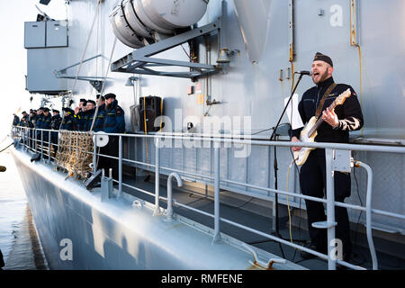 15. Februar 2019, Niedersachsen, Wilhelmshaven: Ein Marine der Fregatte Augsburg steht auf dem Schiff während seiner Rückkehr, Singen und Gitarre spielen. Foto: mohssen Assanimoghaddam/dpa Stockfoto