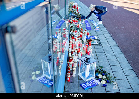 Gelsenkirchen, Deutschland. 15 Feb, 2019. Gedenkfeier für die ehemalige FC Schalke 04-manager Rudi Assauer. Zahlreiche Trauer Kerzen stand auf der tausend Freunde Mauer vor der Veltins Arena, während eine Frau mit einem Fan Schal eine Kerze es setzt. Credit: Marcel Kusch/dpa/Alamy leben Nachrichten Stockfoto