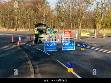 Gullane, East Lothian, Schottland, Großbritannien, 15. Februar 2019. Zwei Autos verwickelt in einen Zusammenstoß Crash auf der A198 Küstenstraße. Die Polizei schließt die Straße mit Barrieren und Straße geschlossen Zeichen Stockfoto