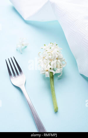 Weiße Hyazinthen und Silber Gabel auf blauem Hintergrund Stockfoto