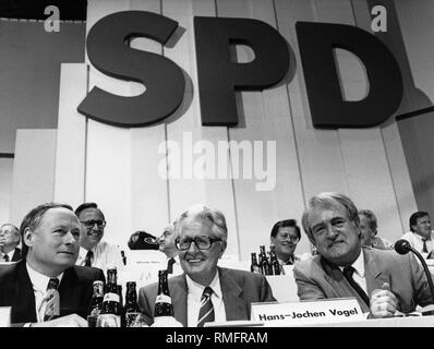SPD-Führung auf dem Parteitag in der Halle Münsterland (von links nach rechts): Der saarlaendische Ministerpraesident Lafontaine Parteivorsitzende Hans-Jochen Vogel und der nordrhein-westfaelische Ministerpraesident Johannes Rau. Im Hintergrund, zwischen Hans Lafontaine und Vogel, Hans Eichel (links) und Horst Ehmke. In der wieder auf den richtigen, Gerhard Schröder. Stockfoto