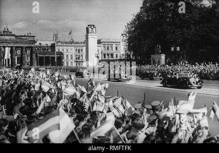 Adolf Hitler Antriebe im vorderen Auto der Konvoi der Legion Condor, der aus dem spanischen Bürgerkrieg zurückgegeben haben, im Lustgarten Berlin. Die Leute in der Straße Unter den Linden (im Hintergrund das Brandenburger Tor) jubeln ihm hinterlassen. Stockfoto