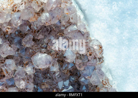 Amethyst natürliche crystal Cluster mit Goethit Einschlüsse aus Brasilien auf weißem Schnee an einem sonnigen Wintertag. Stockfoto