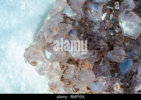 Amethyst natürliche crystal Cluster mit Goethit Einschlüsse aus Brasilien auf weißem Schnee an einem sonnigen Wintertag. Stockfoto