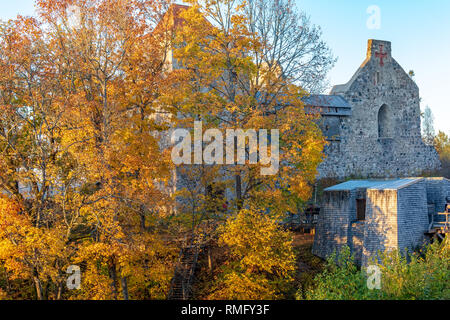 Mittelalterliche Burg des Livländischen Ordens in Sigulda, Lettland, durch orange Herbst Blätter versteckt. Schloss wurde im Jahre 1207 vom Livländischen Brüder des Schwertes, die w Stockfoto