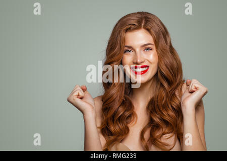 Red head Mädchen mit langen und glänzend lockiges Haar. Glücklich überrascht Frau. Ausdrucksstarke Mimik Stockfoto