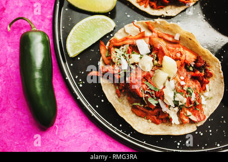 Pfeffer und Kalk in der Nähe von Tacos al Pastor und Saucen Stockfoto