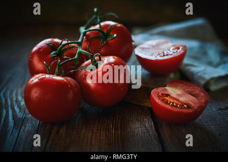 Closeup Haufen nassen reifen Tomaten in der Nähe von Serviette auf Bauholz Tischplatte platziert Stockfoto