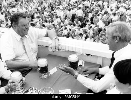 Der Präsident der Präsident des Bayerischen Ministerpräsidenten Franz Josef Strauß (CSU) ist das Gespräch mit dem Bürgermeister von München Georg Kronawitter (rechts, SPD), während ein Liter Bier auf dem Oktoberfest in München. Stockfoto