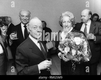 Heinz Ruehmann und seine Frau Hertha am 20. Jahrestag der "Buecherstube Aufkirchen" am Starnberger See, links im Hintergrund der Wirt der Aufkirchner Gemeindebibliothek, Msgr. Alfons Wimmer. (Undatiertes Foto) Stockfoto